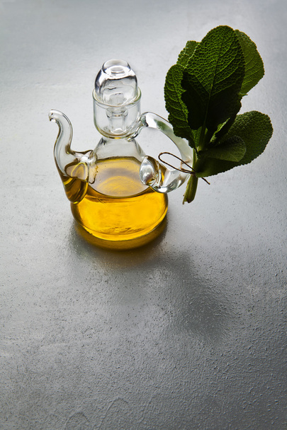 Оливковое масло в стеклянной бутылке. травы
. - Фото, изображение