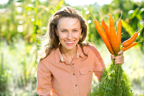 Beautiful gardener with oragenic carrot - Fotó, kép