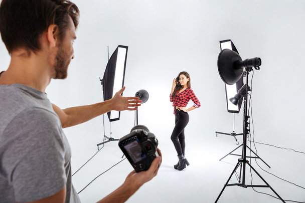 Photographer shooting model in studio - Foto, imagen