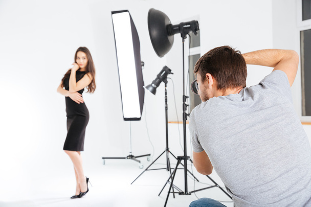 Man shooting female model in studio - Zdjęcie, obraz