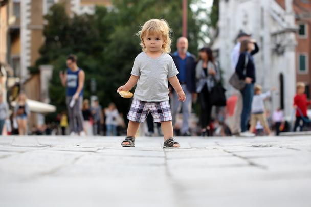 Baby boy with bun on pavement  - Fotografie, Obrázek