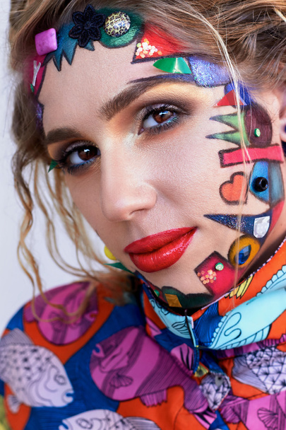  Beautiful woman with bright creative fantasy multicolored makeup, geometric shapes. - Photo, Image