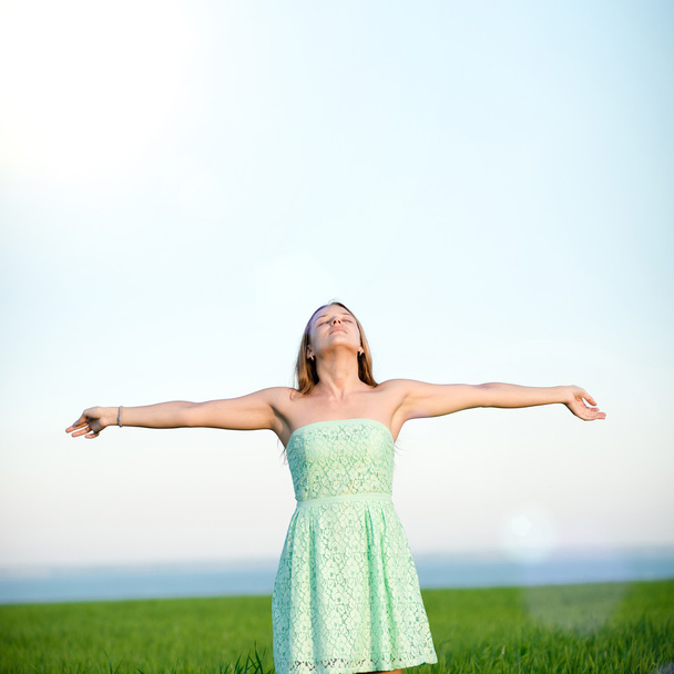 Щастя жінка залишається на відкритому повітрі під сонячним світлом заходу сонця
 - Фото, зображення
