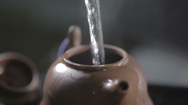Víz ömlött be kerámia teáskanna - Felvétel, videó