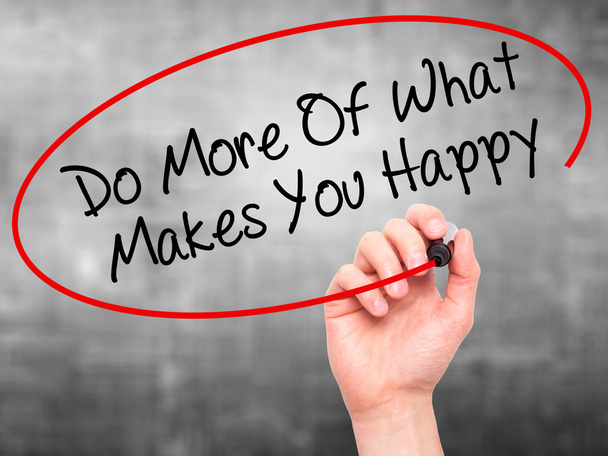 Человек, пишущий "Делай больше того, что делает тебя счастливым" с черной меткой
 - Фото, изображение
