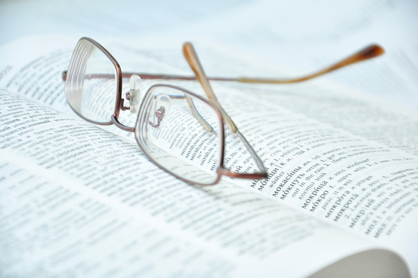 Eyeglasses on open book - Φωτογραφία, εικόνα