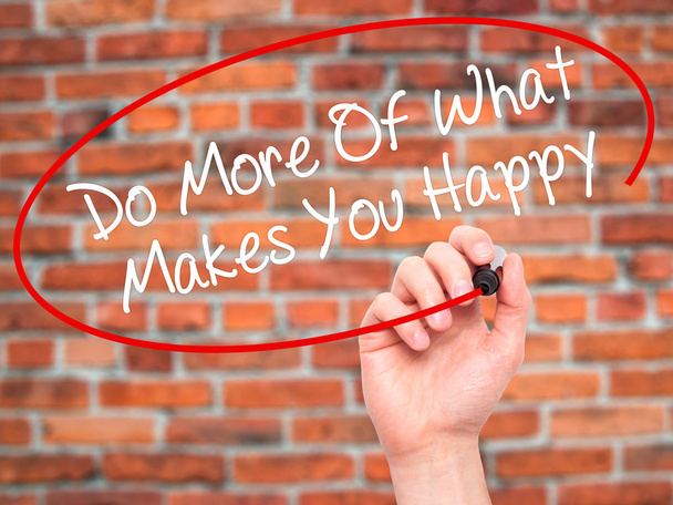 Человек, пишущий "Делай больше того, что делает тебя счастливым" с черной меткой
 - Фото, изображение