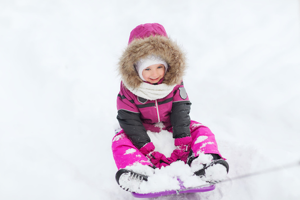 happy little kid on sled outdoors in winter - Zdjęcie, obraz