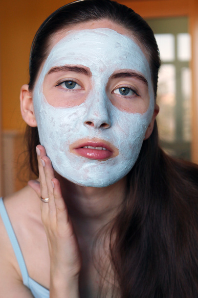 Mujer haciendo máscara cosmética en su cara
 - Foto, Imagen