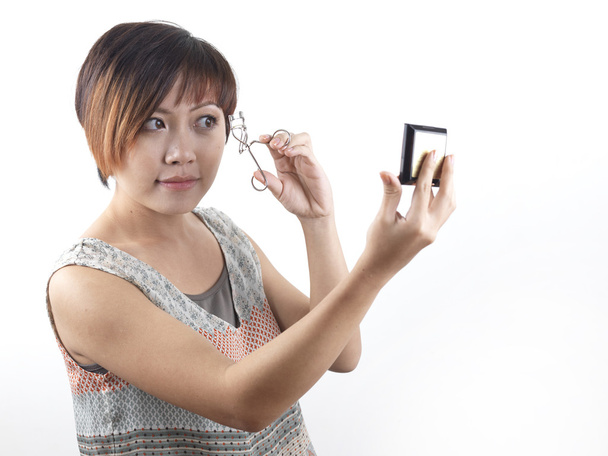 Aziatische chinese vrouw zetten een wimpers - Foto, afbeelding
