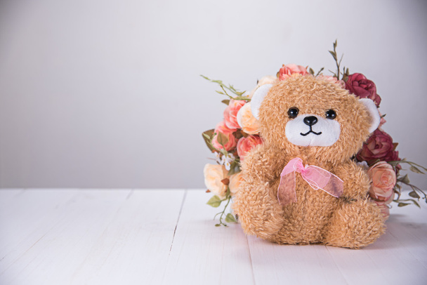 teddy bear with rose on white wooden table - Фото, изображение