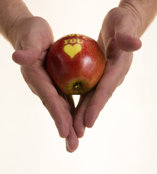 Rode appel in de hand op witte achtergrond - Foto, afbeelding
