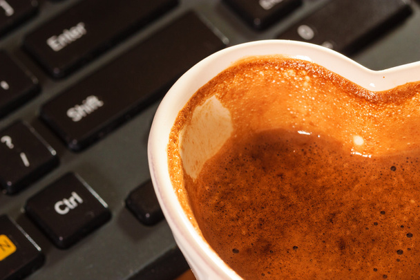 Cup of coffee next to computer keyboard. - Foto, Imagem