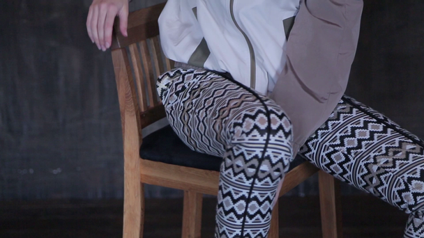 Tyttö sukkahousut istuu tuolilla ja poseeraa
 - Materiaali, video