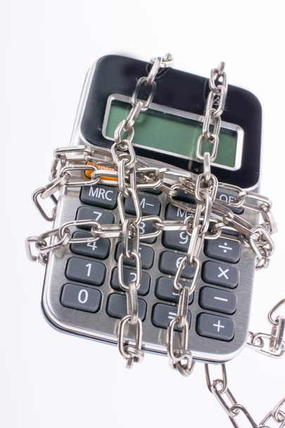 Calculator wrapped in chains on white background - Photo, Image