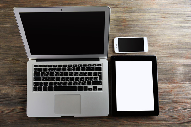 An open silver laptop, mobile phone and tablet  - Fotografie, Obrázek