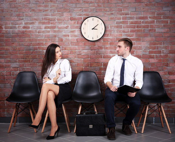 Young businessman and businesswoman sitting on a chairs - Foto, afbeelding