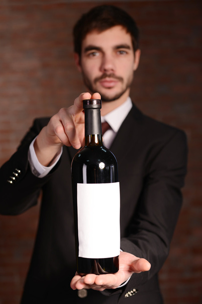 Man holding a bottle of red wine - Zdjęcie, obraz