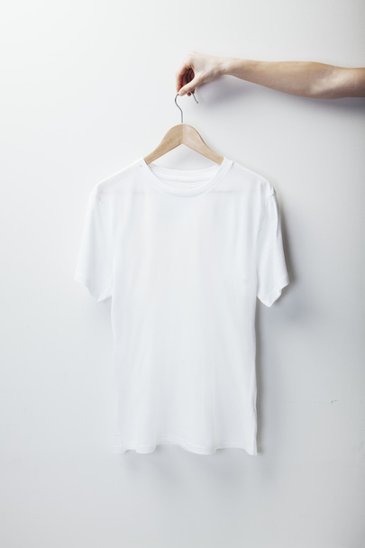Photo of white tshirt hanging female hand - Fotoğraf, Görsel