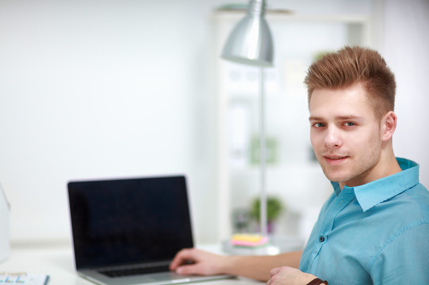 Young businessman working in office, sitting at desk - Foto, imagen