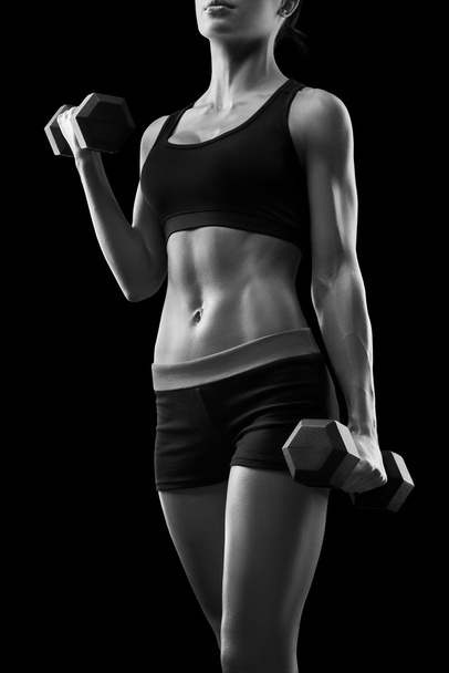 Young fitness woman in training pumping up muscles with dumbbell - Φωτογραφία, εικόνα