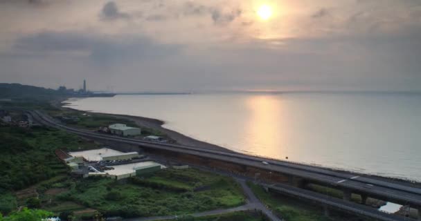 Lapso de tiempo de la puesta del sol en la playa con la carretera a lo largo de, nueva ciudad de taipei, Taiwán - Metraje, vídeo