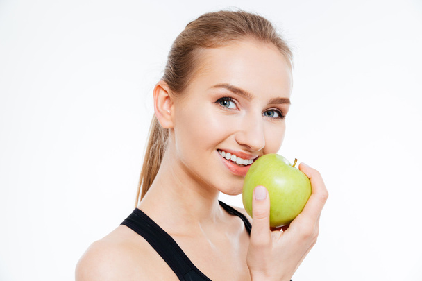Mujer atleta alegre comiendo una manzana
  - Foto, Imagen