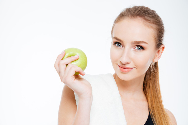 Beautiful young sportswoman holding apple  - Photo, Image