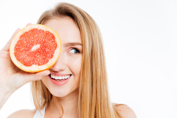 Woman holding slice of grapefruit - Valokuva, kuva
