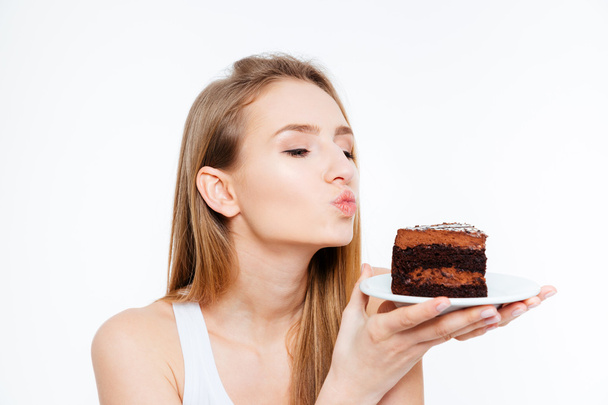 Donna che tiene un pezzo di torta al cioccolato e invia un bacio
  - Foto, immagini
