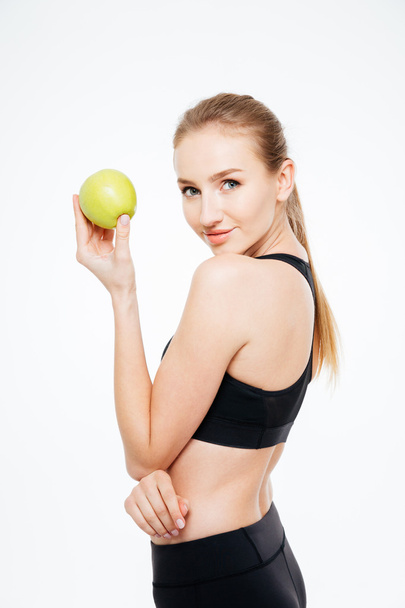 Charmante Sportlerin steht und posiert mit Apfel  - Foto, Bild