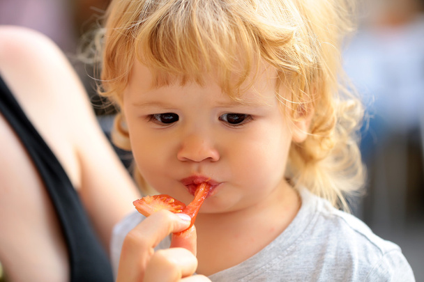 Retrato de niño comiendo tomate
  - Foto, Imagen