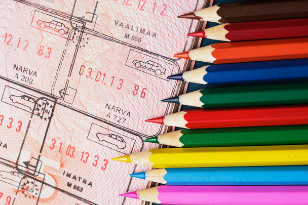Kleurpotloden en een paspoort. verwende documenten - Foto, afbeelding