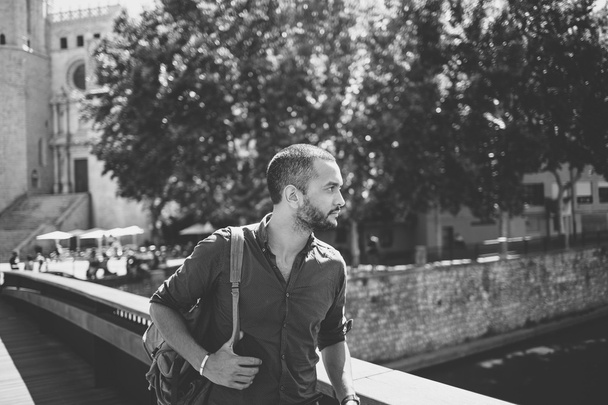 Handsome bearded man walking on bridge and looking away - Fotó, kép