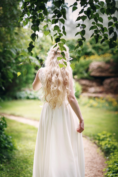 Menyasszony hosszú tisztességes haja hátul a kertben - Fotó, kép