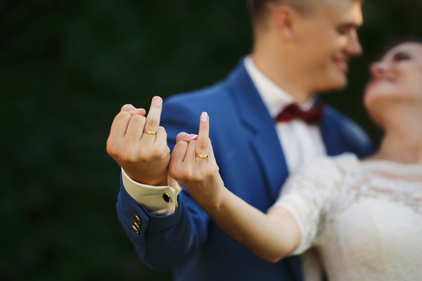 Руки нареченого і нареченого в обручках. Пара грайливо показують свої кільця
 - Фото, зображення