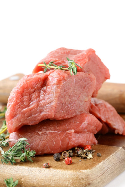 Carne fresca cruda con tomillo y especias en una tabla de cortar
 - Foto, Imagen