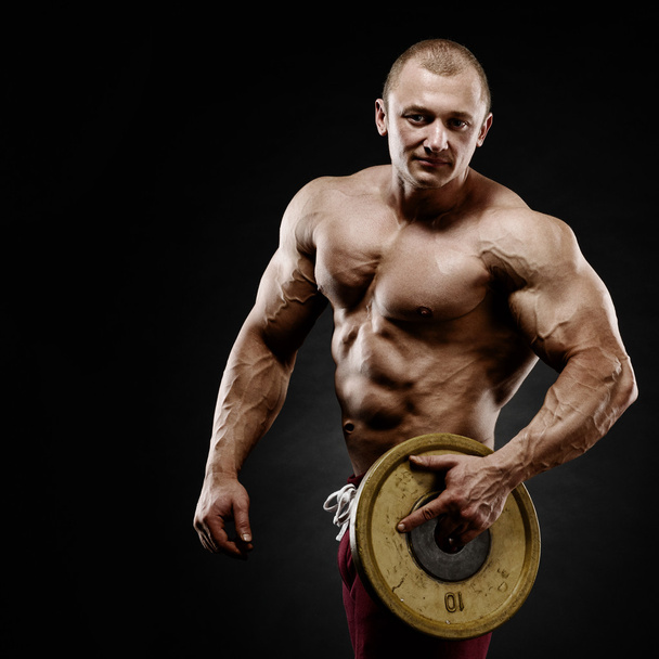 Handsome muscular bodybuilder preparing for fitness training. - Photo, Image