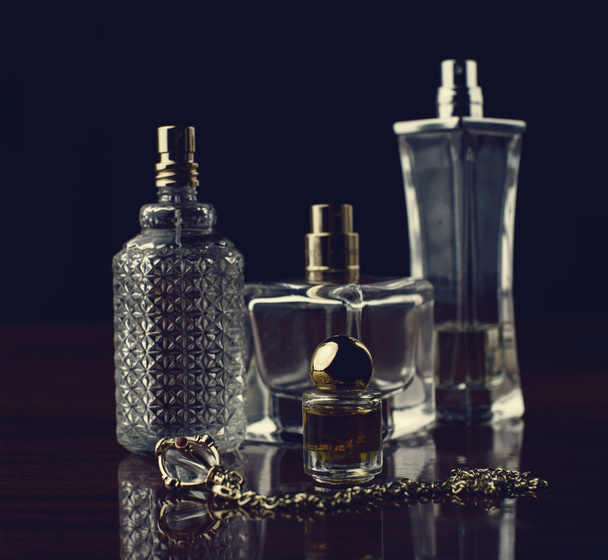 Various bottles of woman perfume on dark background. - Photo, Image