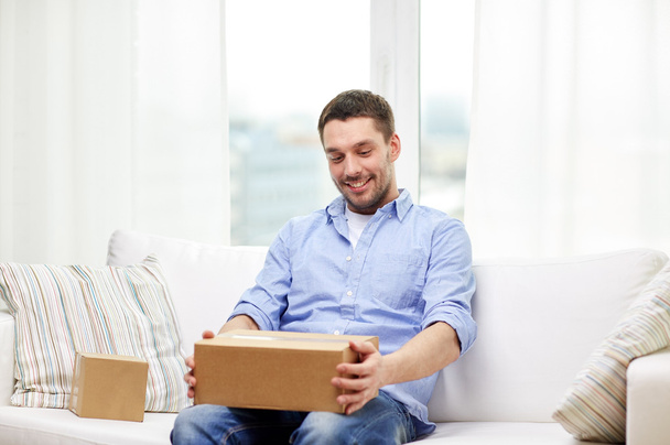 happy man with cardboard boxes or parcels at home - Foto, imagen