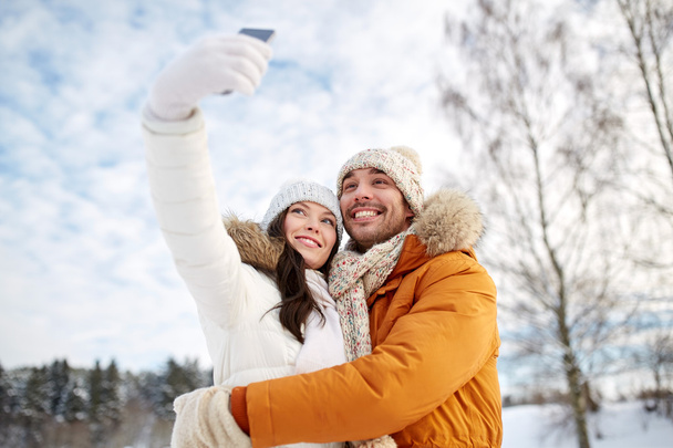 happy couple taking selfie by smartphone in winter - Zdjęcie, obraz