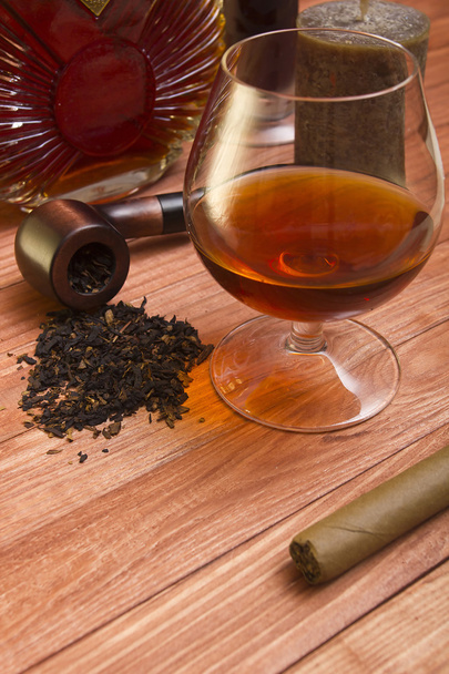 Cognac and tobacco pipe on a wooden table - Foto, Imagen