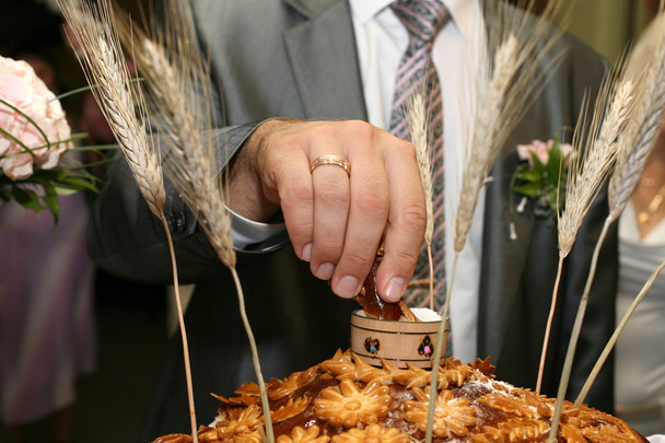 bruidegom zout gebroken stuk van bruiloft brood - Foto, afbeelding