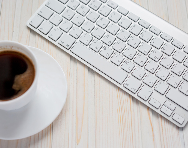 weißer Laptop mit Kaffeetasse auf altem Holztisch. - Foto, Bild