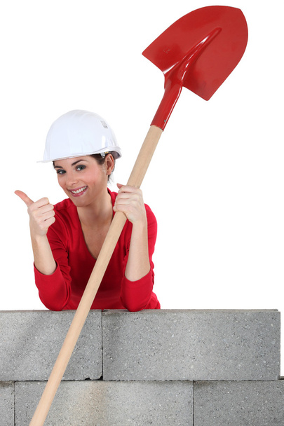 Female mason with shovel, giving the thumbs-up - Foto, imagen