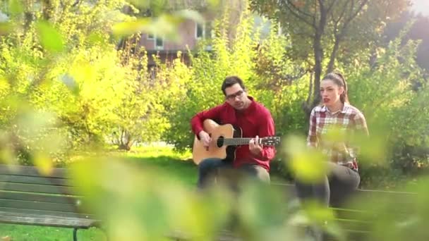 man playing guitar and woman - Video, Çekim
