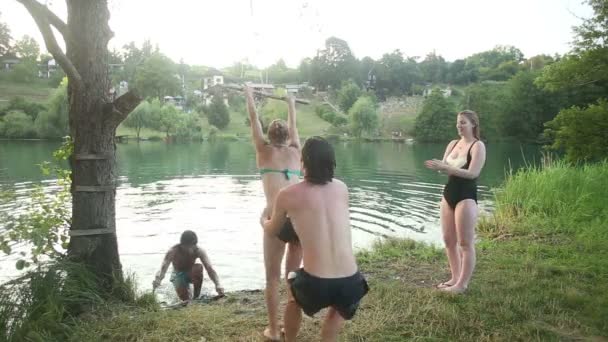 Freunde springen von Seilschaukel in Fluss - Filmmaterial, Video