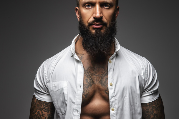 Een man met tattooes op zijn armen  - Foto, afbeelding