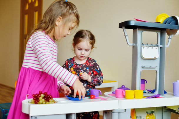 children  playing toy kitchen - Фото, изображение