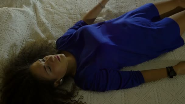 Młoda kobieta leży na łóżku: przygnębiony, zmęczony, samotny - Materiał filmowy, wideo